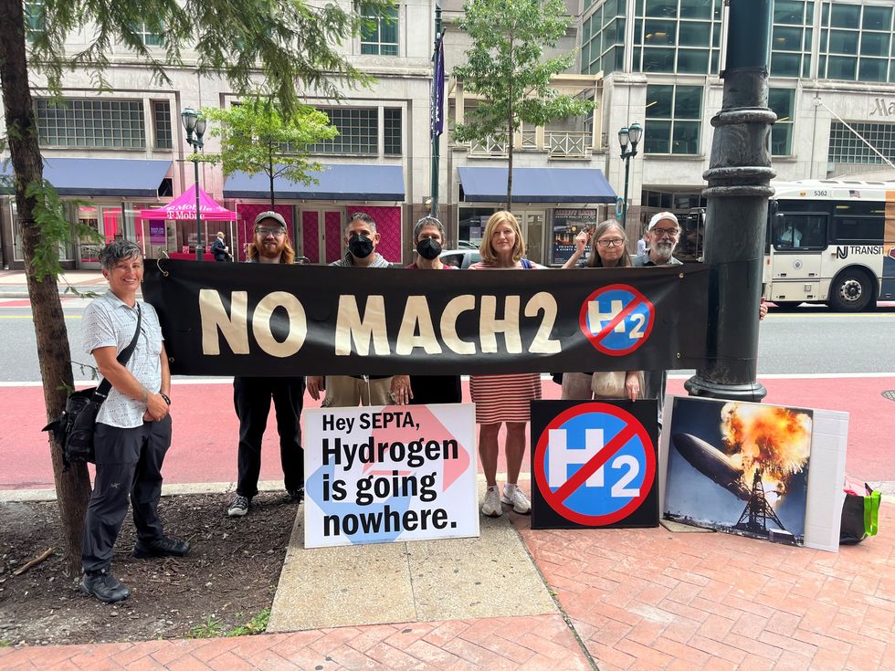 People holding sign that says NO MACH2